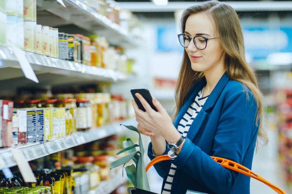 woman in grocery, using loyalty program app